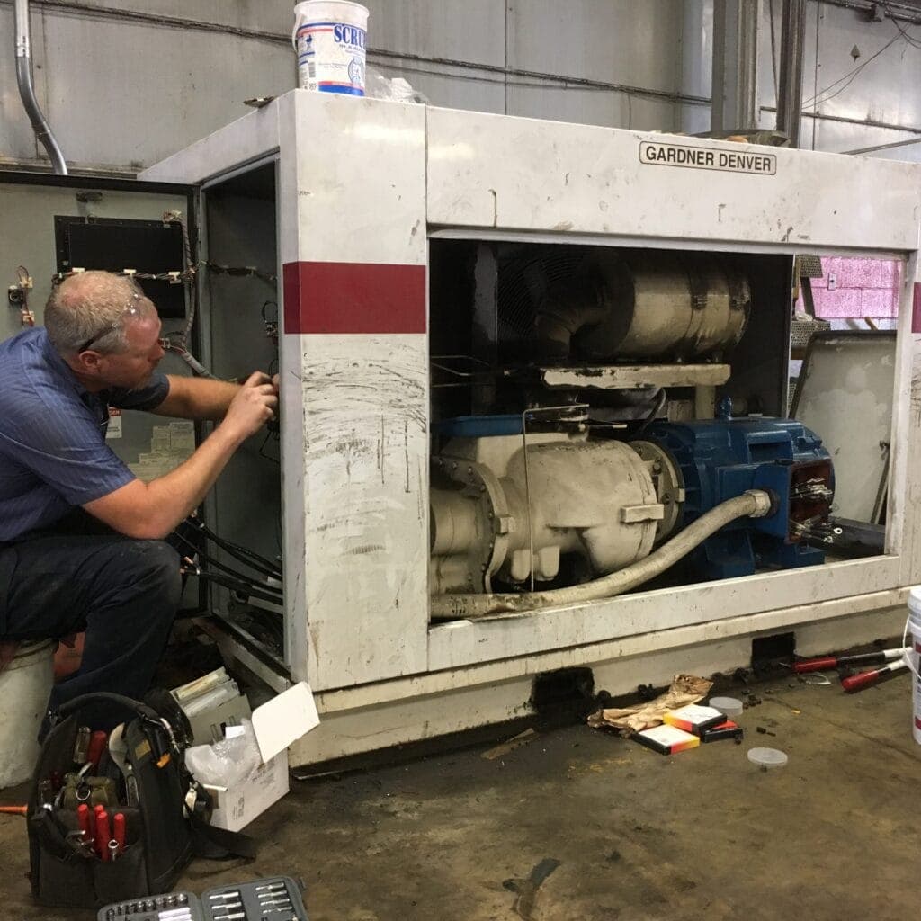 person repairing industrial air compressor