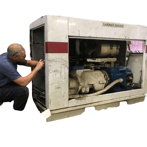 technician performing preventive maintenance on an industrial air compressor