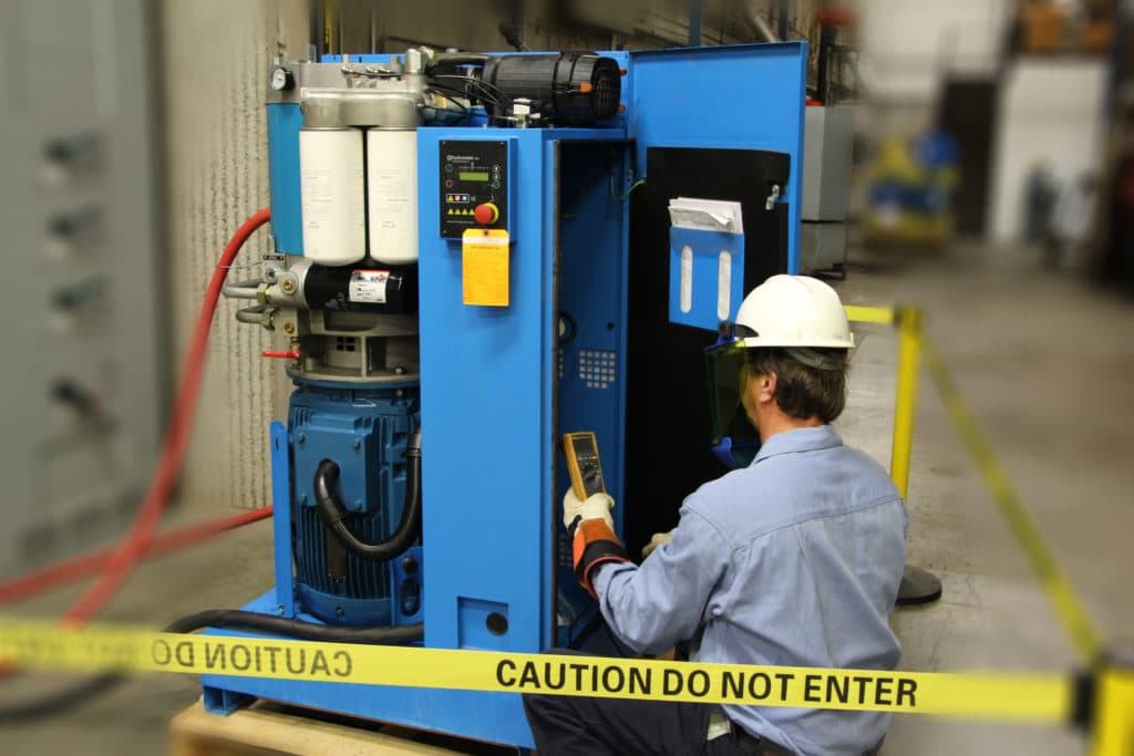 person doing an oil change on an air compressor